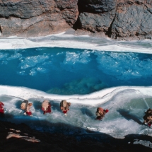 Une caravane de villageois sur le fleuve gele du Zanskar (Himalaya indien) / A caravan of village people walking along the frozen edges of the river Zanskar (Indian Himalaya)