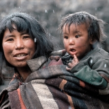 Une jeune mere et son fils emerveille par les premiers flocons de neige a Charka dans la haute vallee du Dolpo (Nepal) / Young mother and her son, marvelling at the snow flakes starting to fall in Charkha, Dolpo valley (Nepal)