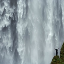 Wen Yutao au pied des chutes de Skogarfoss en Islande. / Wen Yutao at the foot of the Skogarfoss falls in Iceland.